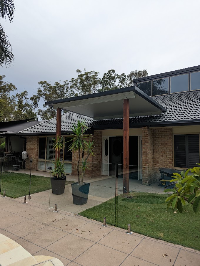 Brick home with a tiled patio and established palms