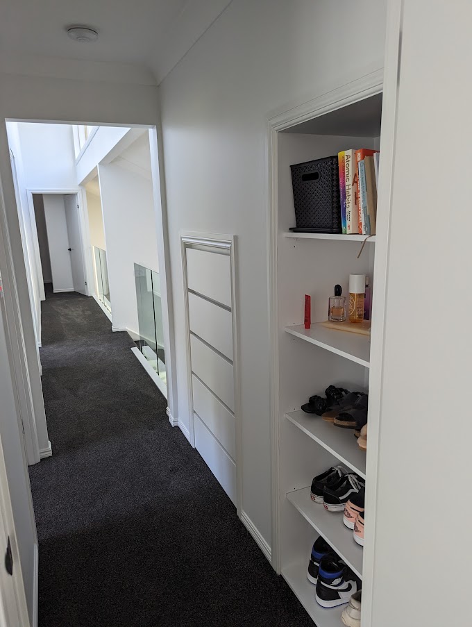 Hallway with built-in shelving and dark carpet