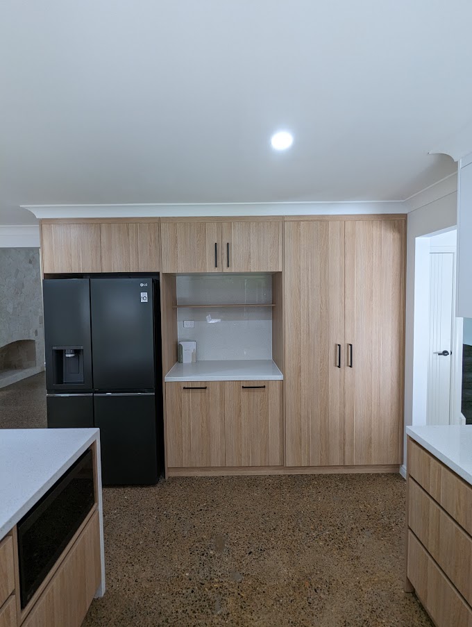 Kitchen with timber-look cabinetry and a black fridge