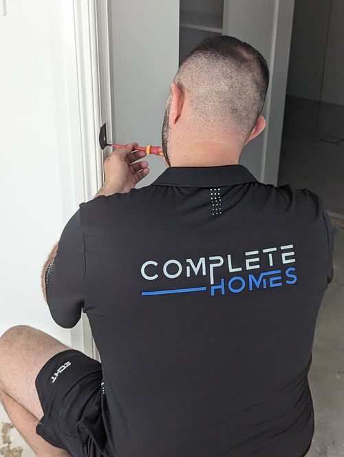 A Complete Homes tradesman fitting a door handle during a Gold Coast renovation