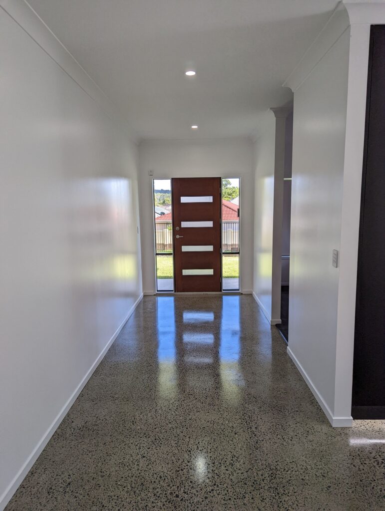 Entry hallway with polished concrete floors and a timber front door, Carrara