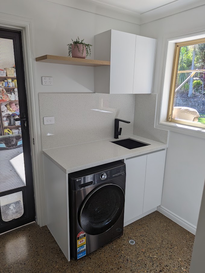 Renovated laundry with white cabinetry, a timber shelf and terrazzo-look floor, Gaven