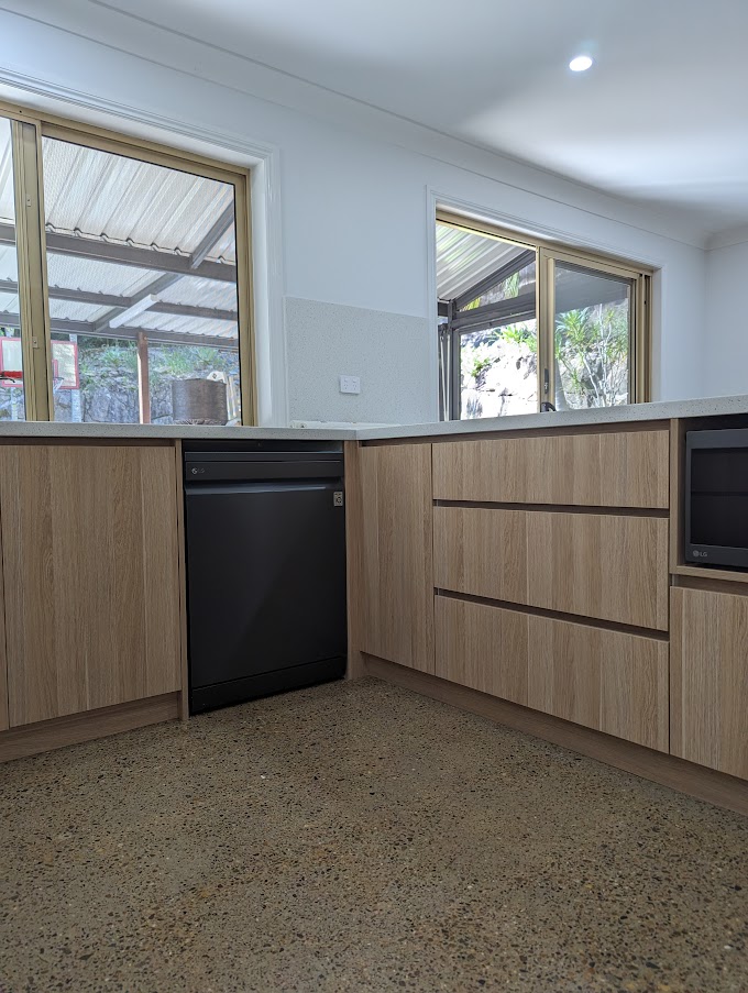 Renovated kitchen with timber-look cabinetry, stone benchtops and an integrated dishwasher
