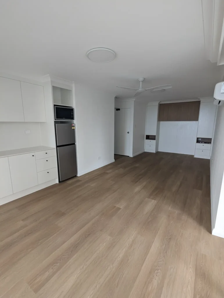 Renovated open-plan apartment living area with timber-look flooring, Surfers Paradise