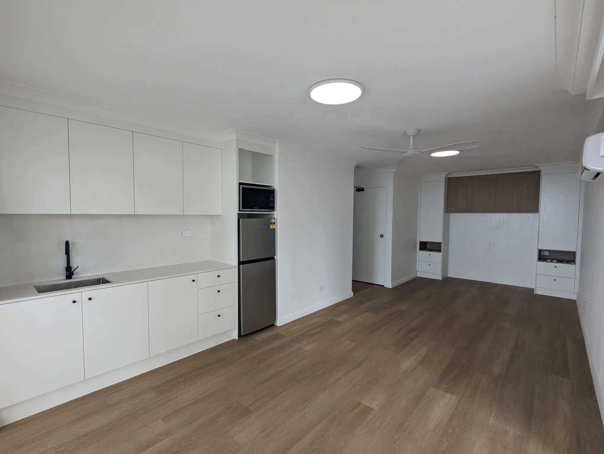Renovated apartment kitchen and open living area with timber-look flooring, Surfers Paradise