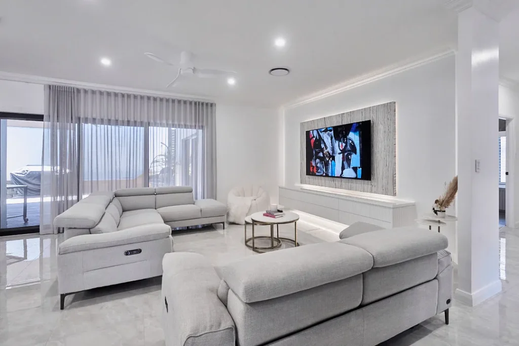 Renovated living room with a stone feature TV wall and sliding doors to the deck, Varsity Lakes