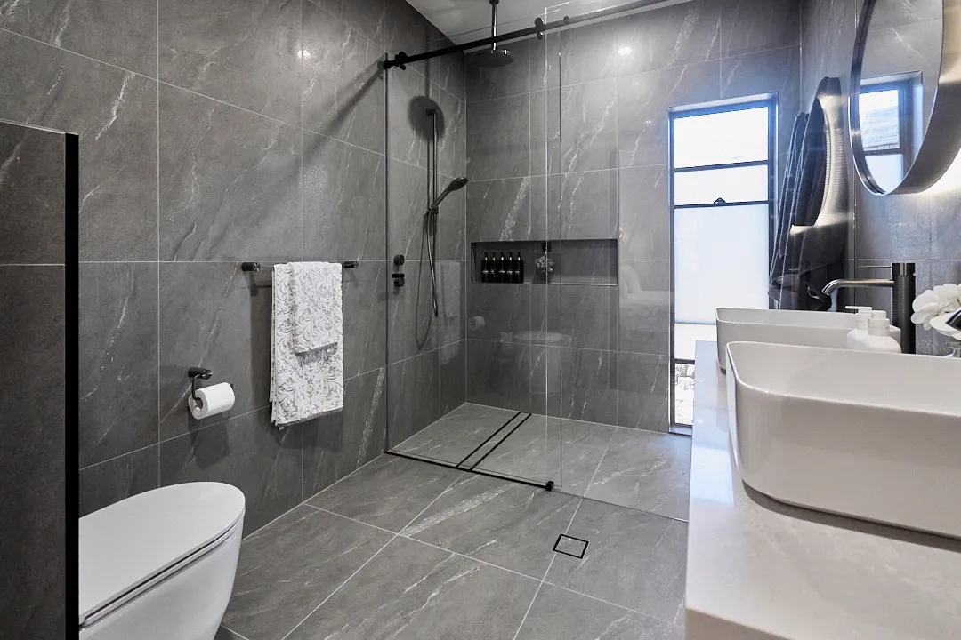Renovated bathroom with charcoal marble-look tiles, a walk-in shower and black tapware, Varsity Lakes