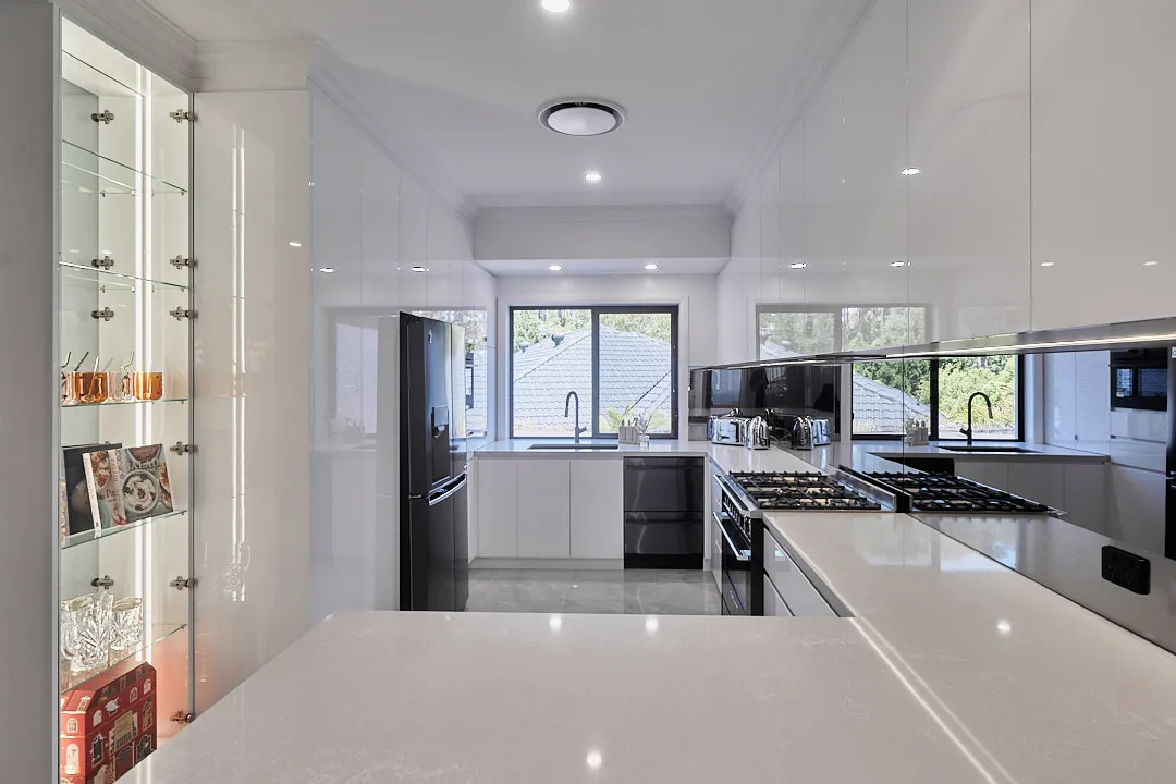 White gloss kitchen with a glass display cabinet, mirror splashback and gas cooktop, Varsity Lakes