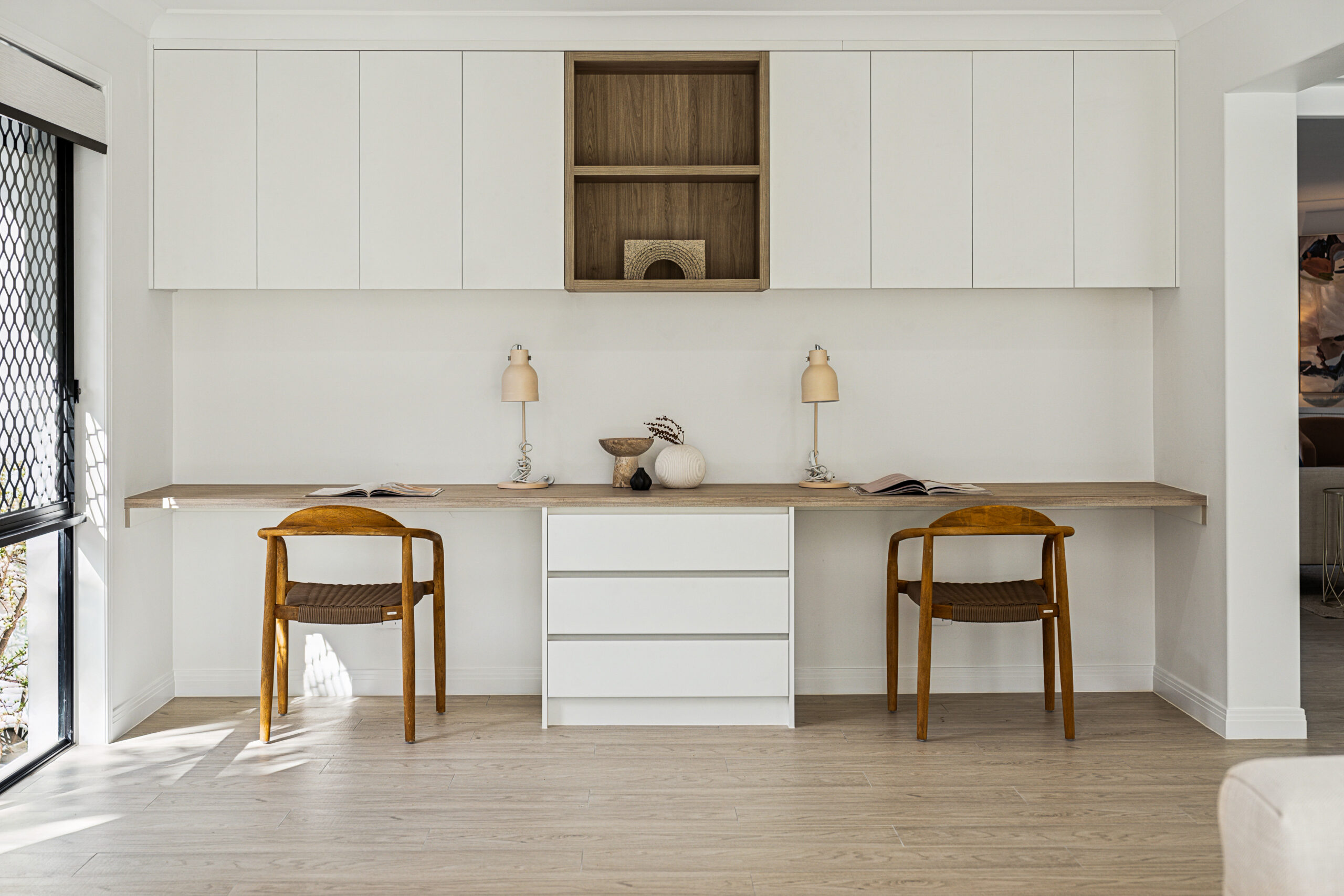 Built-in study nook with white joinery, timber benchtop and two timber chairs, Robina renovation