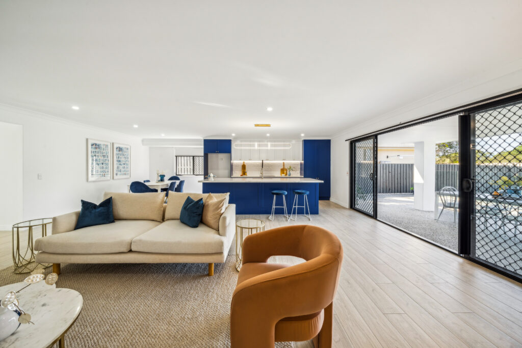 Open-plan living area opening through to the navy kitchen after a whole-home renovation in Robina
