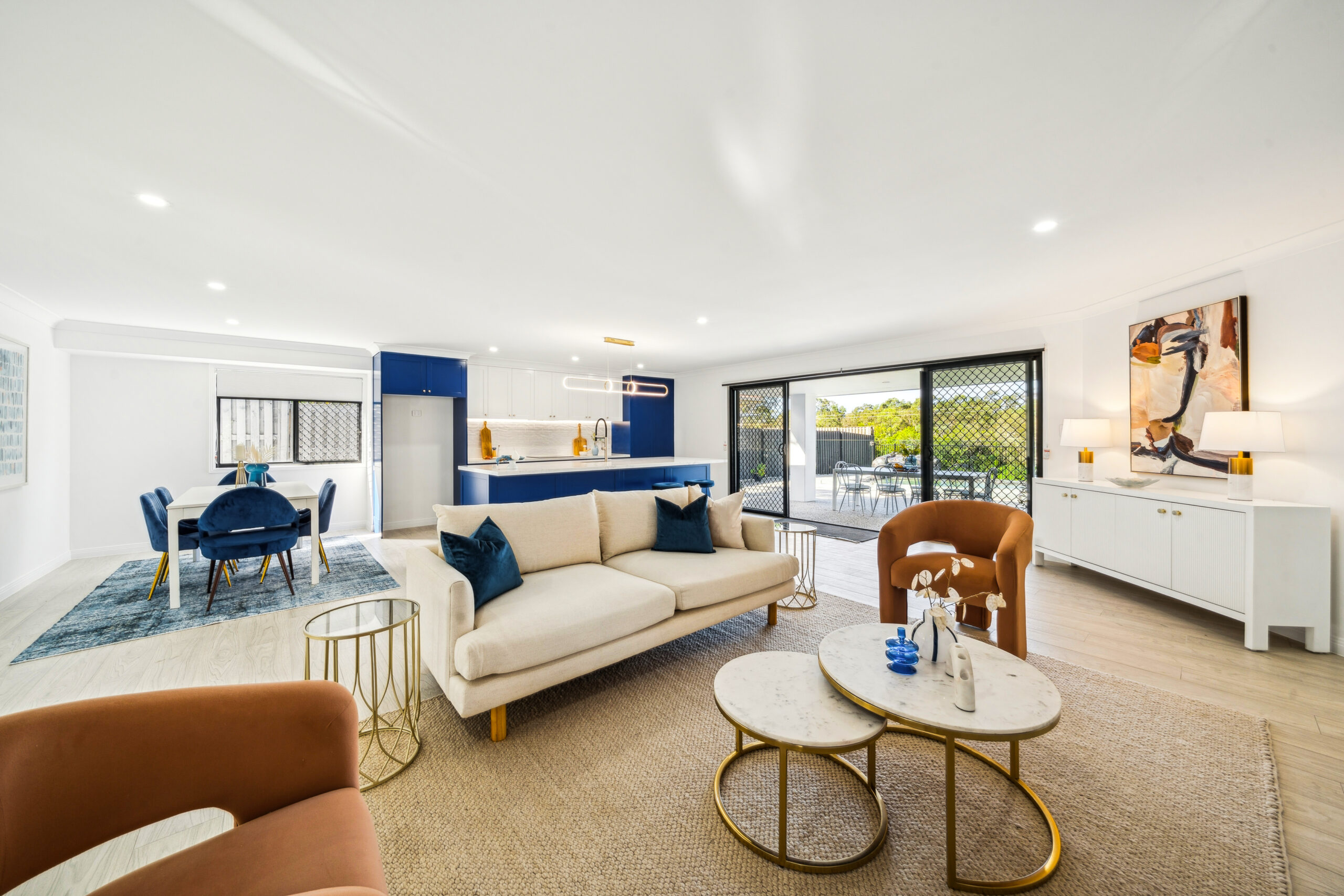 Open-plan living and dining looking through to the navy kitchen, Robina whole-home renovation