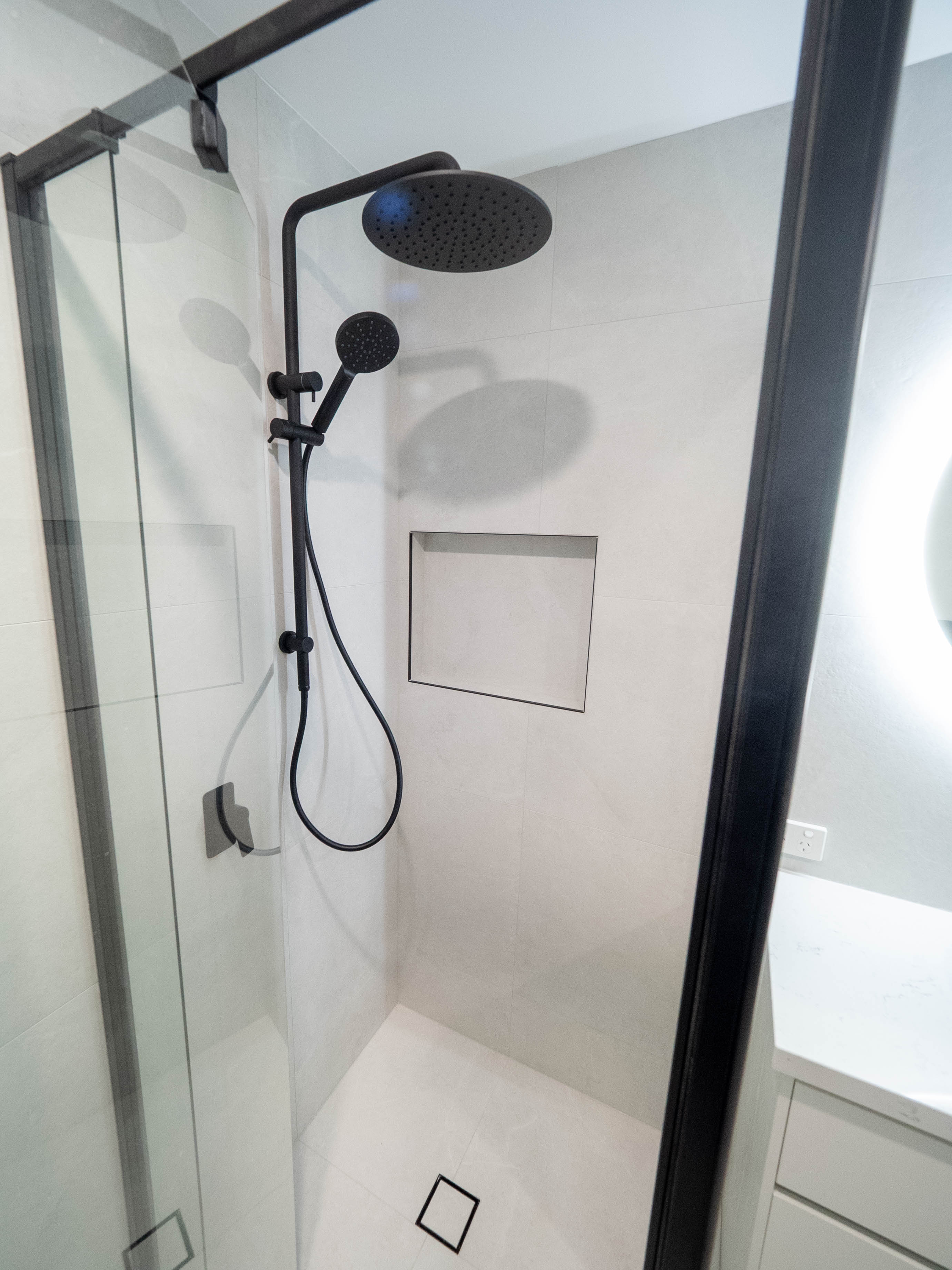 Walk-in shower with black rainfall and handheld shower fittings and a tiled niche, Lower Beechmont