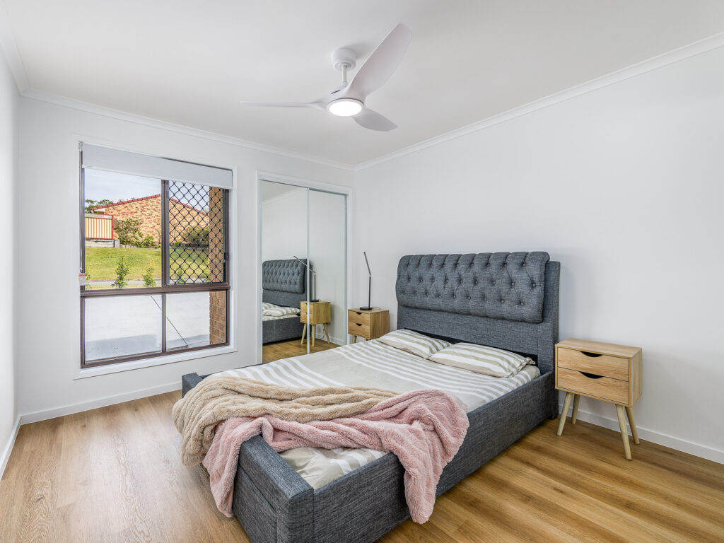 Renovated bedroom with timber-look flooring, mirrored wardrobe and ceiling fan, Arundel
