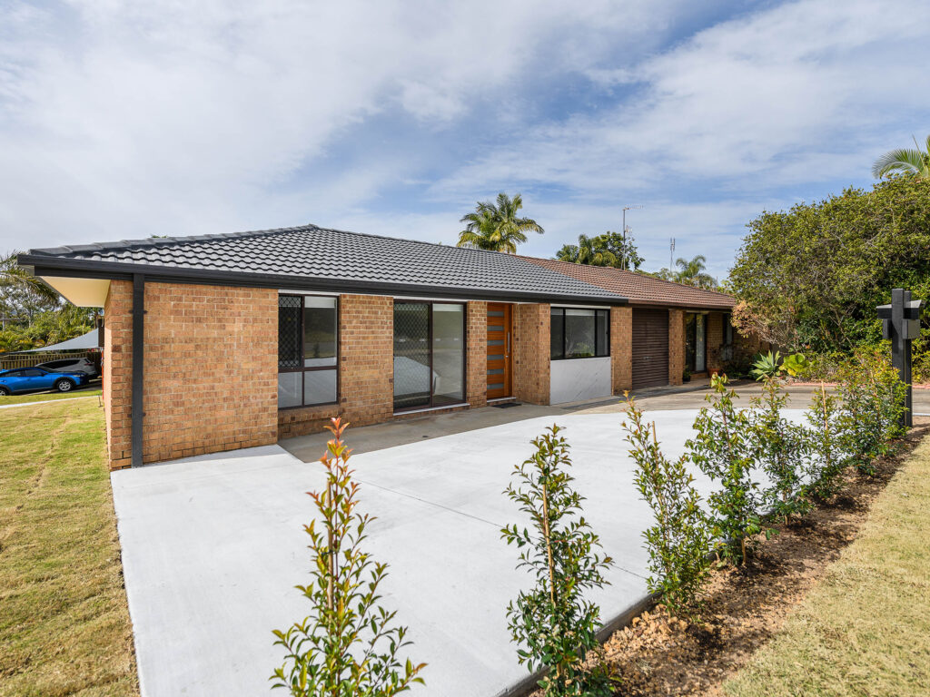 Street view of the renovated brick home with new roofing, driveway and landscaping, Arundel