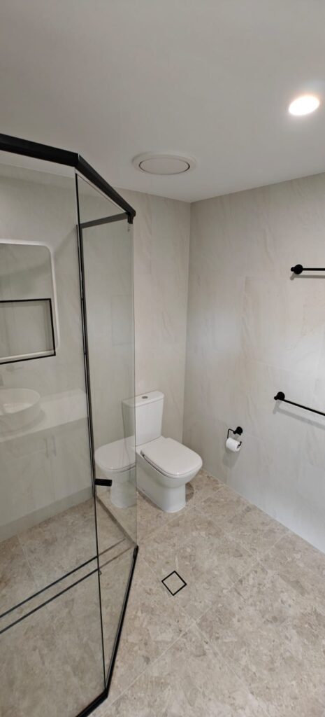 Walk-in shower with a black frame and toilet in the renovated bathroom, Ormeau
