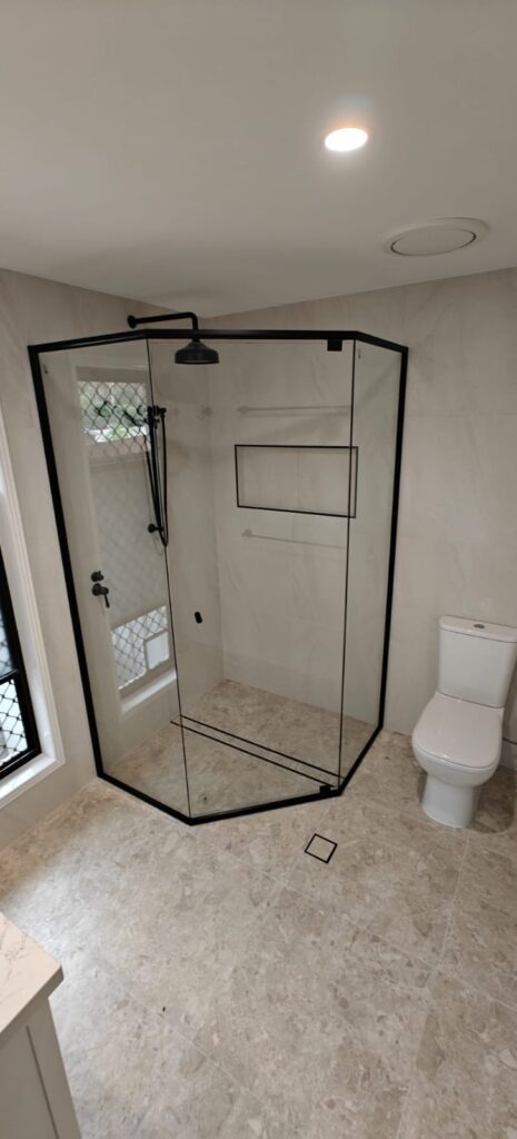 Renovated bathroom with a black-framed corner shower and stone-look floor tiles, Ormeau