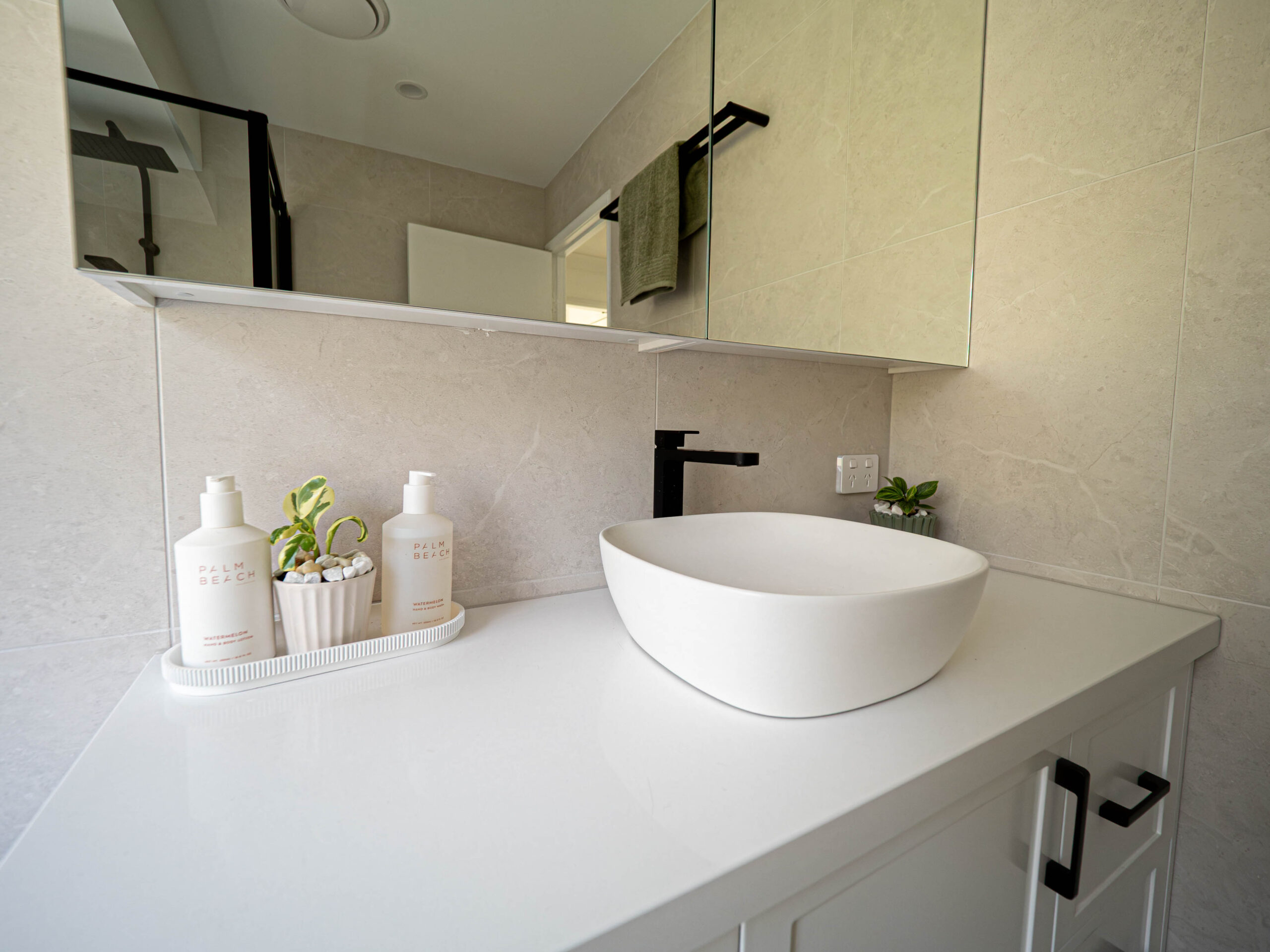 Renovated bathroom vanity with a white vessel basin, stone benchtop and black tapware, Gaven